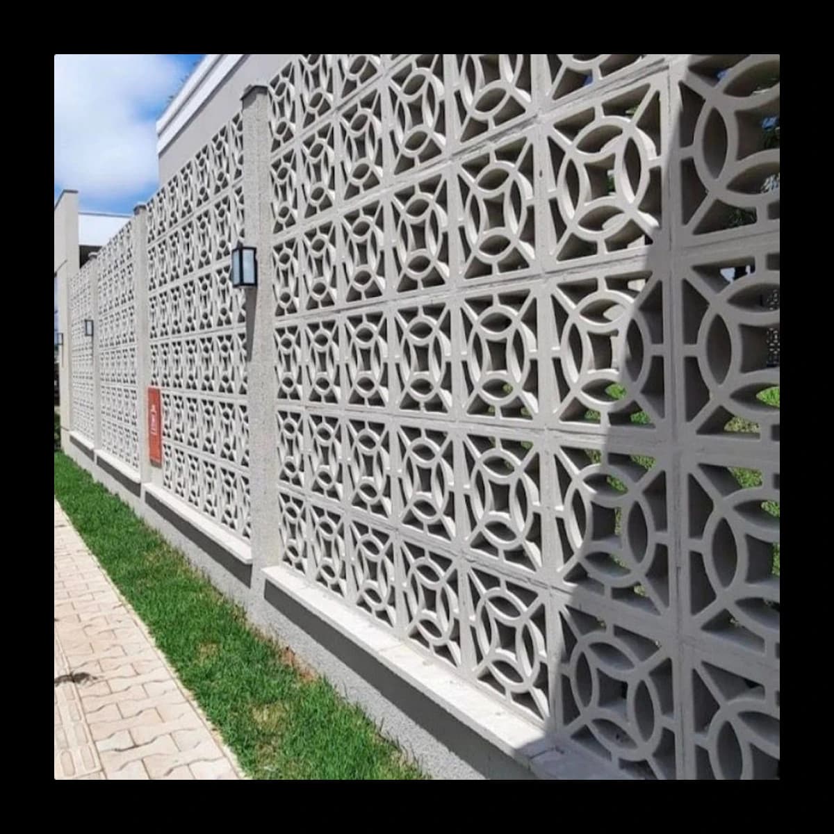 Muro alto residencial em cobogó modelo Eclipse de concreto pré-moldado, padrão de círculos entrelaçados, fachada da Central do Concreto Ivoti RS