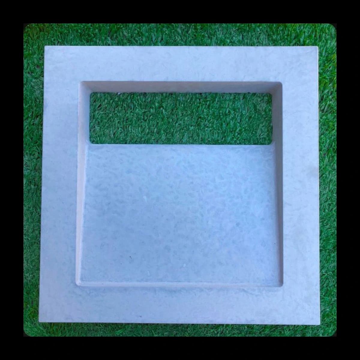 Cobogó modelo Horizon Dupla Face em concreto pré-moldado · rasgo horizontal único na parte superior, miolo recuado, face dupla, fundo de grama sintética · Central do Concreto Ivoti RS