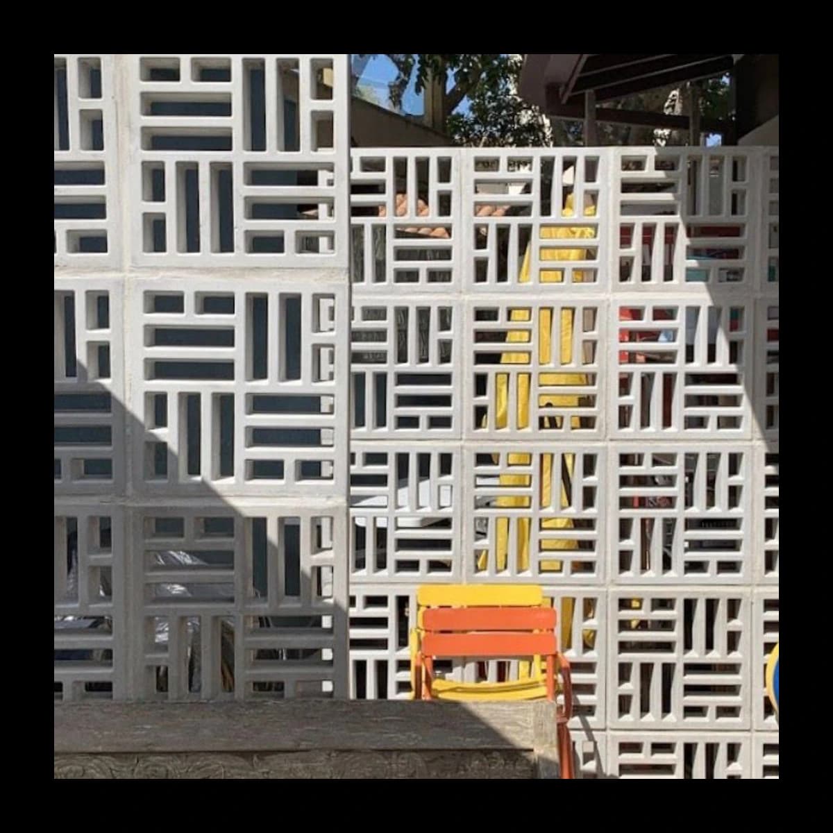 Muro construído com cobogós Taco Chinês em concreto pré-moldado, padrão de barras horizontais e verticais alternadas, ambiente externo iluminado · Central do Concreto Ivoti RS