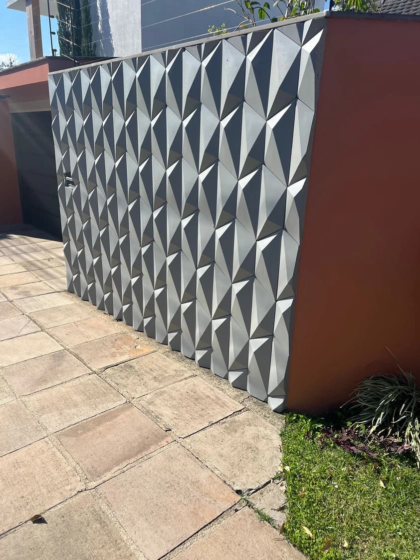 Muro residencial com revestimento Diamante 3D cimentício · facetas diagonais formando padrão em alto relevo · Central do Concreto Ivoti RS