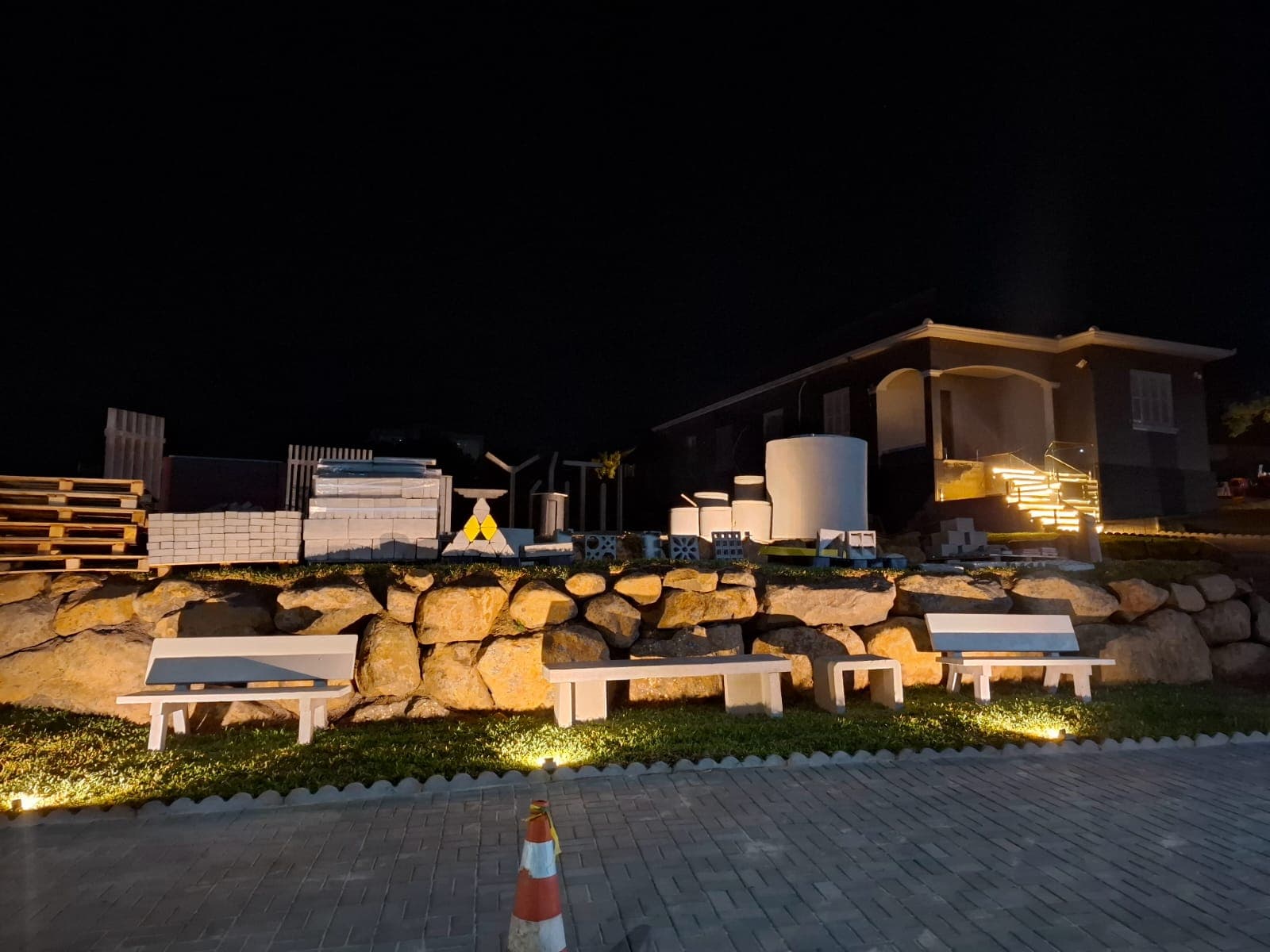 Showroom noturno da Central do Concreto em Ivoti com pátio iluminado e produtos pré-moldados em exposição