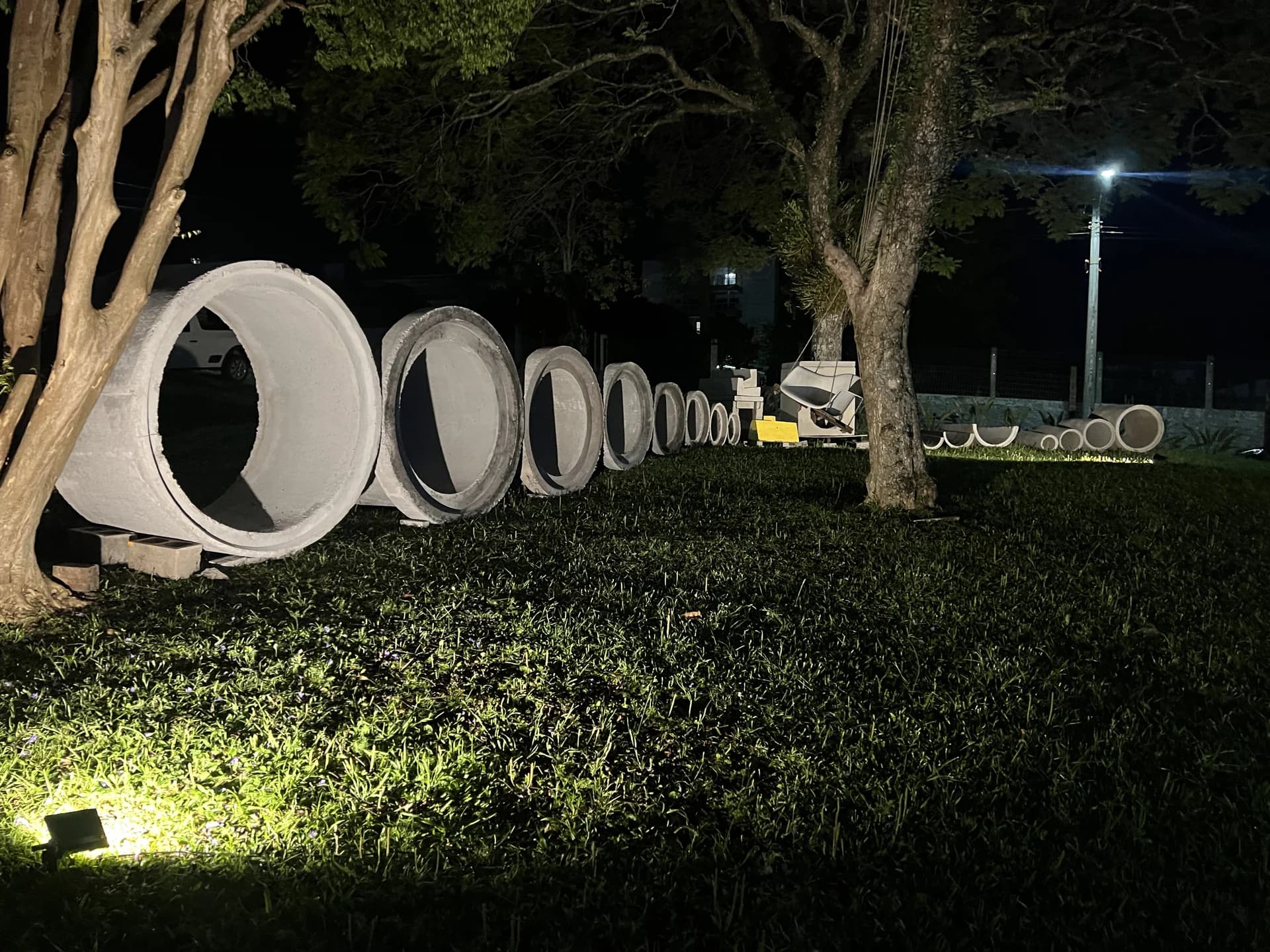 Tubos de concreto de vários diâmetros enfileirados no pátio iluminado da Central do Concreto em Ivoti, do Ø150 cm ao Ø20 cm em ordem decrescente — todos os diâmetros em pronta entrega.