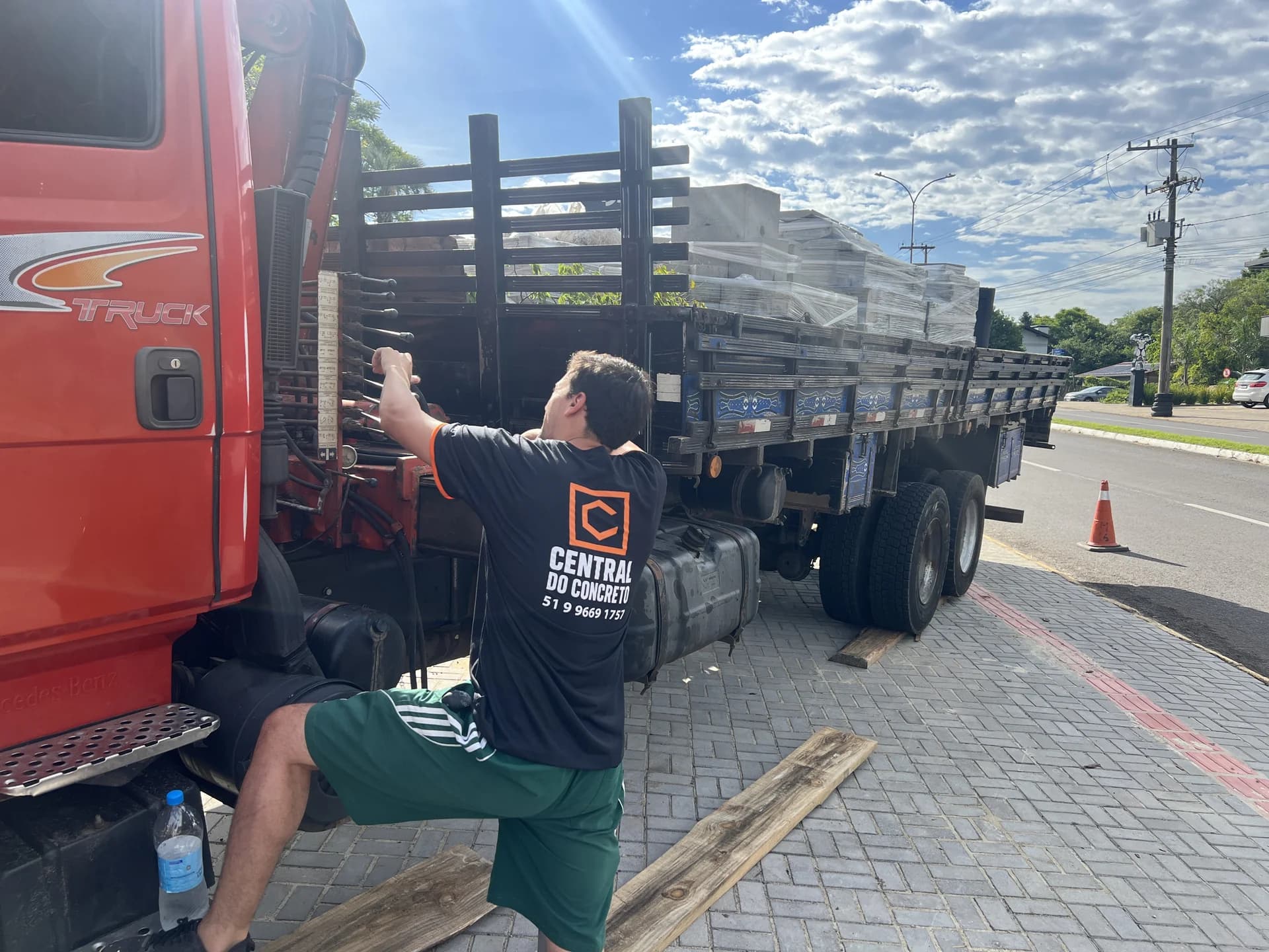 Colaborador da Central do Concreto com uniforme da empresa preparando o caminhão munck para entrega de tubos de concreto em Ivoti.