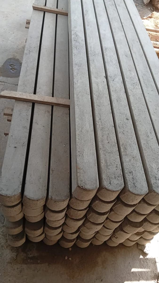 Mourões de concreto retos para cerca empilhados, com o acabamento do concreto armado à vista