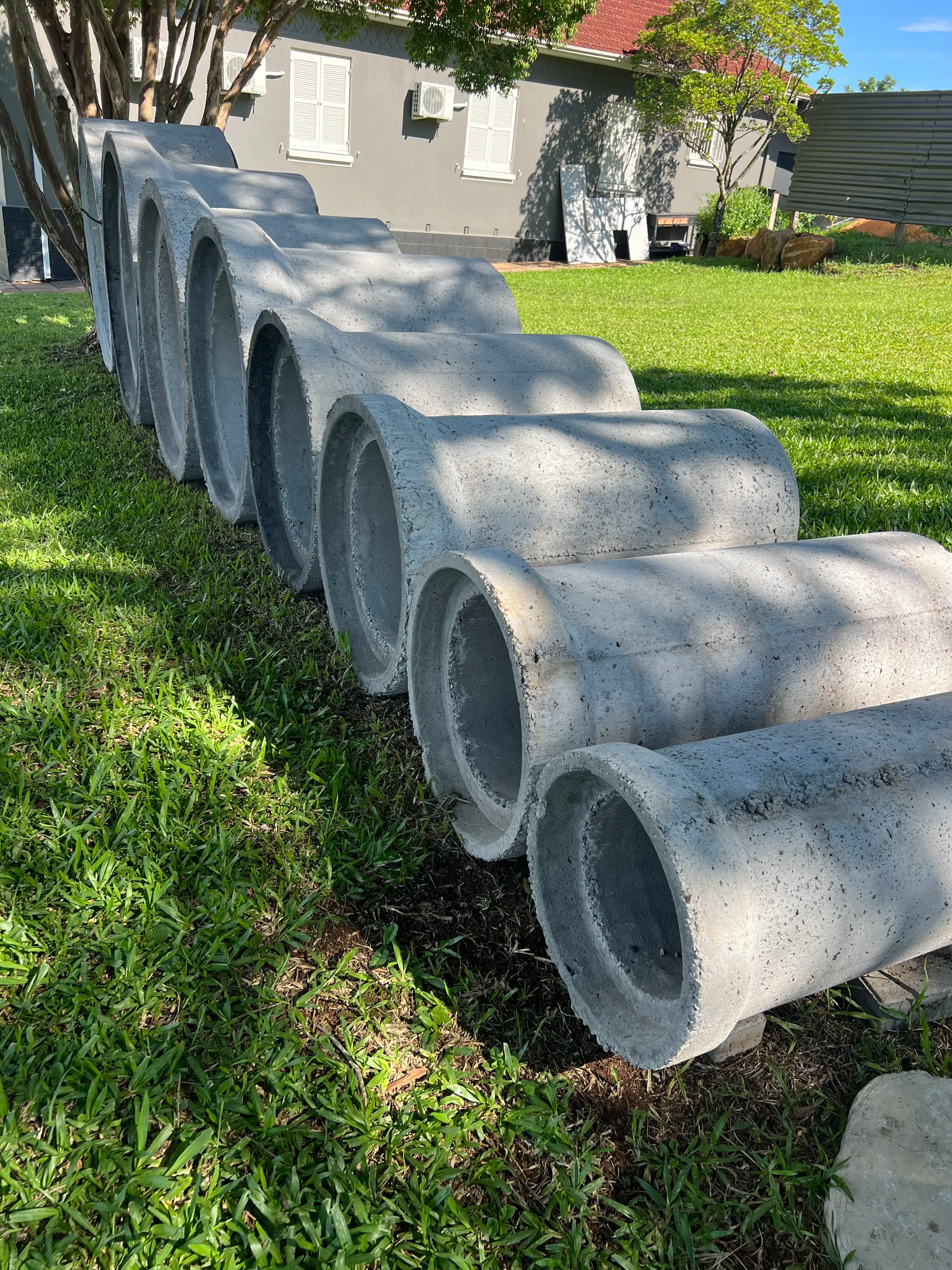 Fileira de tubos de concreto em perspectiva lateral mostrando diâmetros variados — Central do Concreto Ivoti